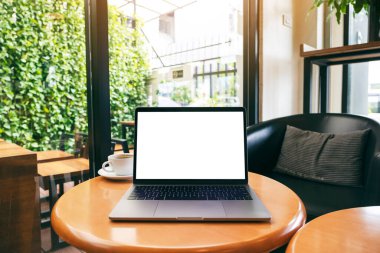 Tahta masadaki boş beyaz masaüstü ekranlı dizüstü bilgisayarın görüntüsü 