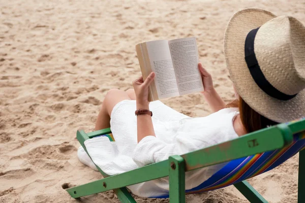 美しい女性が横になり リラックスした気持ちでビーチチェアに本を読んで — ストック写真