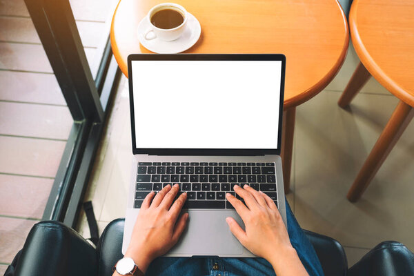 Top view mockup image of a woman using and typing on laptop keyboard with blank white desktop screen 