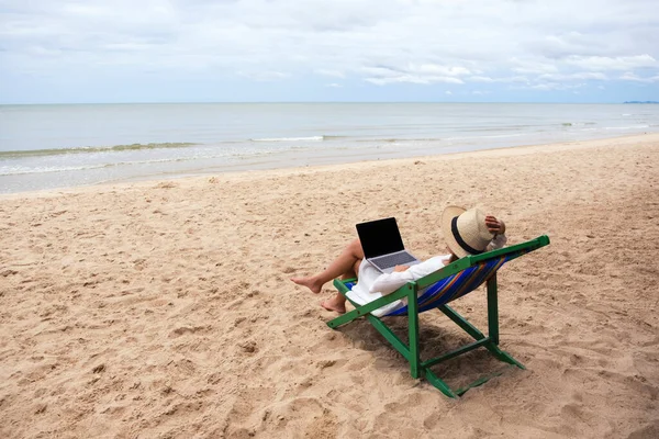 Женщина Использующая Печатающая Ноутбуке Лежа Пляжном Стуле — стоковое фото