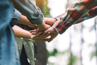 Açık havada el ele tutuşan insanların yakın görüntüsü.