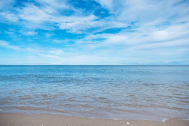 Mavi deniz ve gökyüzü arkaplanlı tropikal beyaz plajın manzara görüntüsü