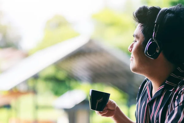 Ένας Ασιάτης Απολαμβάνει Ακούει Μουσική Ακουστικά Ενώ Πίνει Καφέ — Φωτογραφία Αρχείου