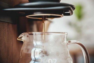 Bir şişenin içine dökülen damlayan kahvenin yakın plan görüntüsü. 