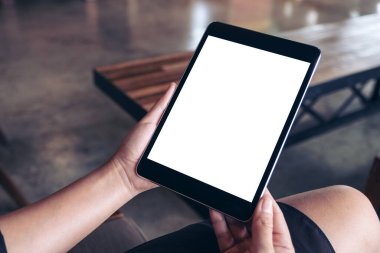 Boş beyaz masaüstü ekran ile siyah tablet bilgisayarını tutan bir kadının en üst görünüm görüntüsü 