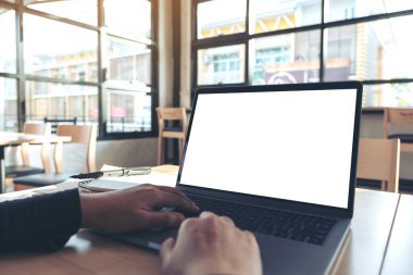 Ofiste otururken boş beyaz masaüstü ekran kullanan ve yazan ellerin görüntüsü