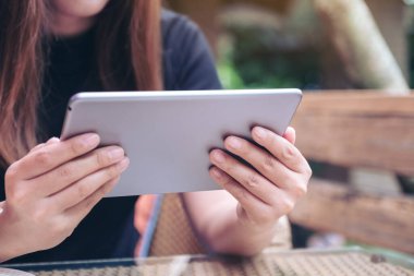 Modern kafede elinde tablet tablet kullanan bir kadının yakın plan görüntüsü