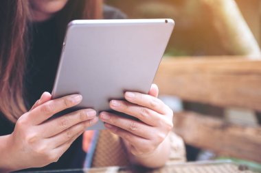 Kafede elinde tablet bilgisayar kullanan bir kadının yakın plan görüntüsü