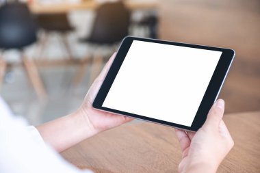 Ofiste otururken boş beyaz masaüstü ekranlı siyah tablet bilgisayarın el ele tutuşunu ve kullanımını görüntüle