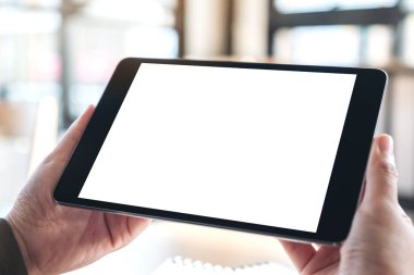 Boş beyaz masaüstü ekranlı siyah tablet pc 'yi tutan ve kullanan elleri görüntüle 