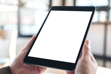 Boş beyaz masaüstü ekranlı siyah tablet pc 'yi tutan ve kullanan elleri görüntüle 
