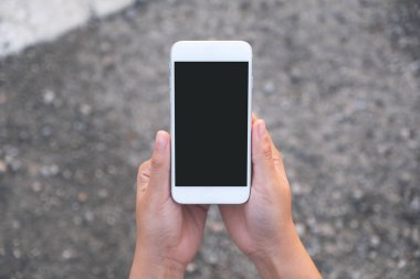 Üst görünüm görüntüsü sokak arkaplanlı beyaz cep telefonu ile boş siyah ekran 
