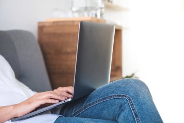 Klavyede rahatça oturup dizüstü bilgisayar kullanan ve daktilo kullanan kadının yakın plan resmi