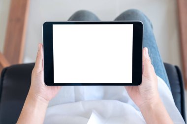 Sandalyede otururken elinde siyah tablet olan beyaz ekranlı bir kadının en üstteki görüntüsü