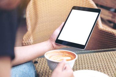 Modern kafede kahve içerken elinde tabletle tablet tutan kadınların görüntüsü.