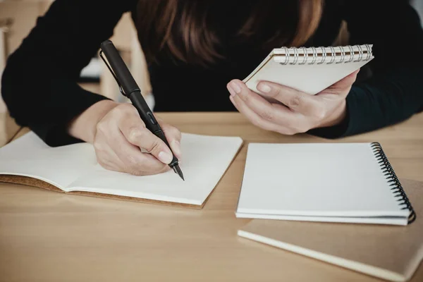 Uma Mulher Segurando Escrevendo Caderno Enquanto Sentado Café Com Borrão — Fotografia de Stock