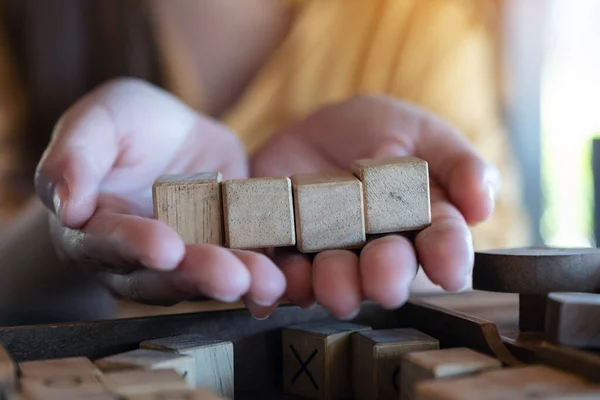 Руки Женщины Держатся Показывают Четыре Квадратных Деревянных Блока — стоковое фото