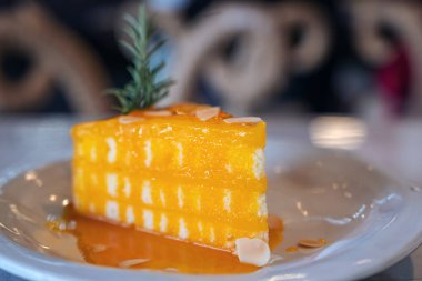 Seramik tabakta turuncu bir kekin yakın plan görüntüsü.