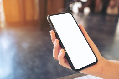 Boş beyaz masaüstü ekran ile siyah cep telefonu tutan bir elin görüntüsü