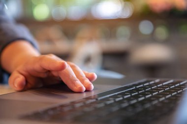 Ellerin ahşap masadaki dizüstü bilgisayarın dokunmatik dokunmatik görüntüsü.