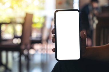 Bir el ele tutuşmanın ve kafeteryada bulanık arkaplan ile boş masaüstü ekranı olan siyah bir cep telefonu görüntüsünün maketi