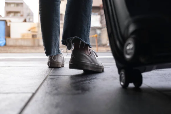 Gezerken Dışarıda Siyah Bir Bavulu Sürüklerken Bir Kadının Ayaklarının Görüntüsü — Stok fotoğraf