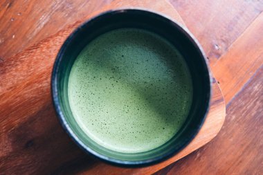 Ahşap zeminde bir fincan sıcak kibrit sütlü kahve.