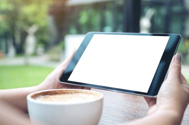 Siyah tabletli, beyaz ekranlı, kahve fincanı ve doğa arka planlı bir kadının görüntüsü.