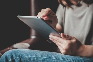 Modern kafedeki tablet bilgisayarını kullanan, kullanan ve işaret eden bir kadının yakın plan görüntüsü.