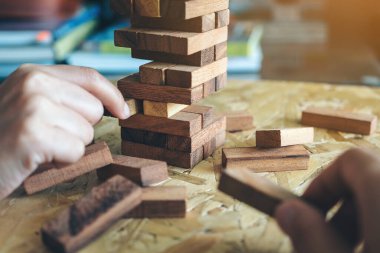 El ele tutuşup Tumble kulesi tahta blok oyunu oynarken yakın plan görüntüsü