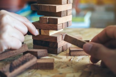 El ele tutuşup Tumble kulesi tahta blok oyunu oynarken yakın plan görüntüsü