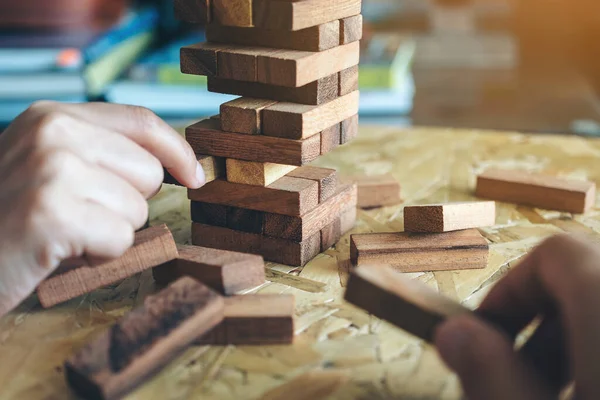 El ele tutuşup Tumble kulesi tahta blok oyunu oynarken yakın plan görüntüsü