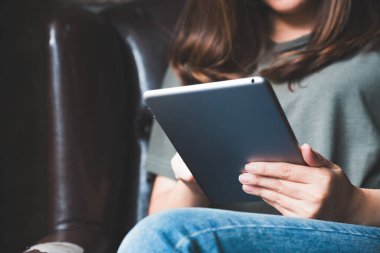 Modern kafede elinde tablet tablet kullanan bir kadının yakın plan görüntüsü