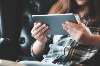 Modern kafede elinde tablet tablet kullanan bir kadının yakın plan görüntüsü
