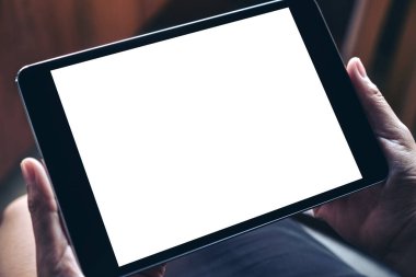 Boş beyaz masaüstü ekranlı siyah tableti tutan ellerin görüntüsü 