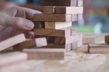 El ele tutuşup Tumble kulesi tahta blok oyunu oynarken yakın plan görüntüsü