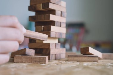 El ele tutuşup Tumble kulesi tahta blok oyunu oynarken yakın plan görüntüsü