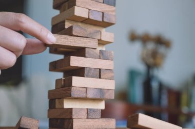 El ele tutuşup Tumble kulesi tahta blok oyunu oynarken yakın plan görüntüsü