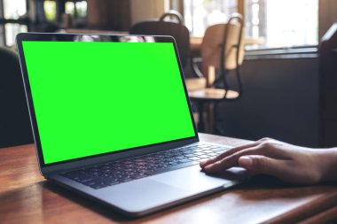 Kafedeki ahşap masada boş masaüstü ekran kullanarak ve yazarak el görüntüsü oluştur