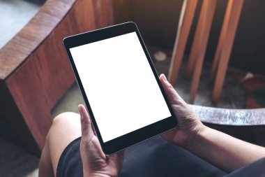 Boş beyaz masaüstü ekran ile siyah tablet bilgisayarını tutan bir kadının en üst görünüm görüntüsü 