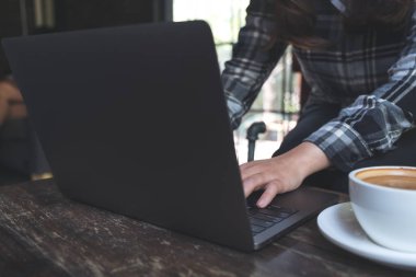 Laptop klavyesinde çalışan ve daktilo kullanan bir kadının yakın plan fotoğrafı.