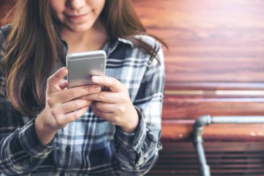 Elinde tutan, kullanan ve akıllı telefona bakan bir kadının yakın plan görüntüsü. 