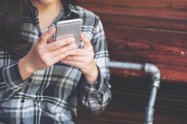 Elinde tutan, kullanan ve akıllı telefona bakan bir kadının yakın plan görüntüsü. 