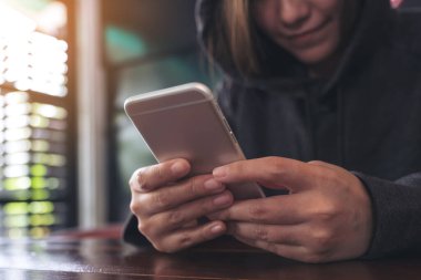 Elinde tutan, kullanan ve akıllı telefona bakan bir kadının yakın plan görüntüsü. 