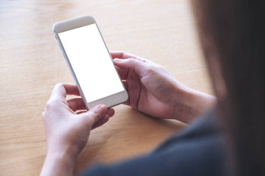 Beyaz ekranlı beyaz bir cep telefonu tutan ve kullanan kadının görüntüsü.