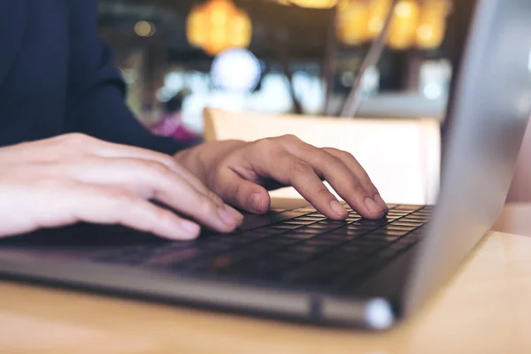 テーブルの上でノートパソコンのキーボードを操作して入力するビジネスマンのイメージを閉じる — ストック写真