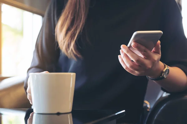 Imagen Cerca Una Mujer Sosteniendo Usando Teléfono Inteligente Mientras Bebe — Foto de Stock