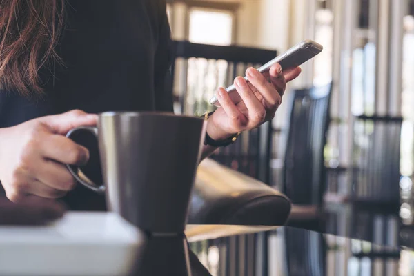 Imagen Cerca Una Mujer Sosteniendo Usando Teléfono Inteligente Mientras Bebe — Foto de Stock