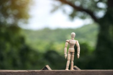 Ahşap figürün yakın plan resmi. Arka planı bulanık, ahşap bir masada duran bir adamın.