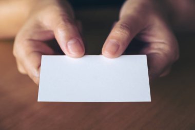 El ele tutuşmanın ve ofisteki birine boş bir kartvizit vermenin yakın çekimi.